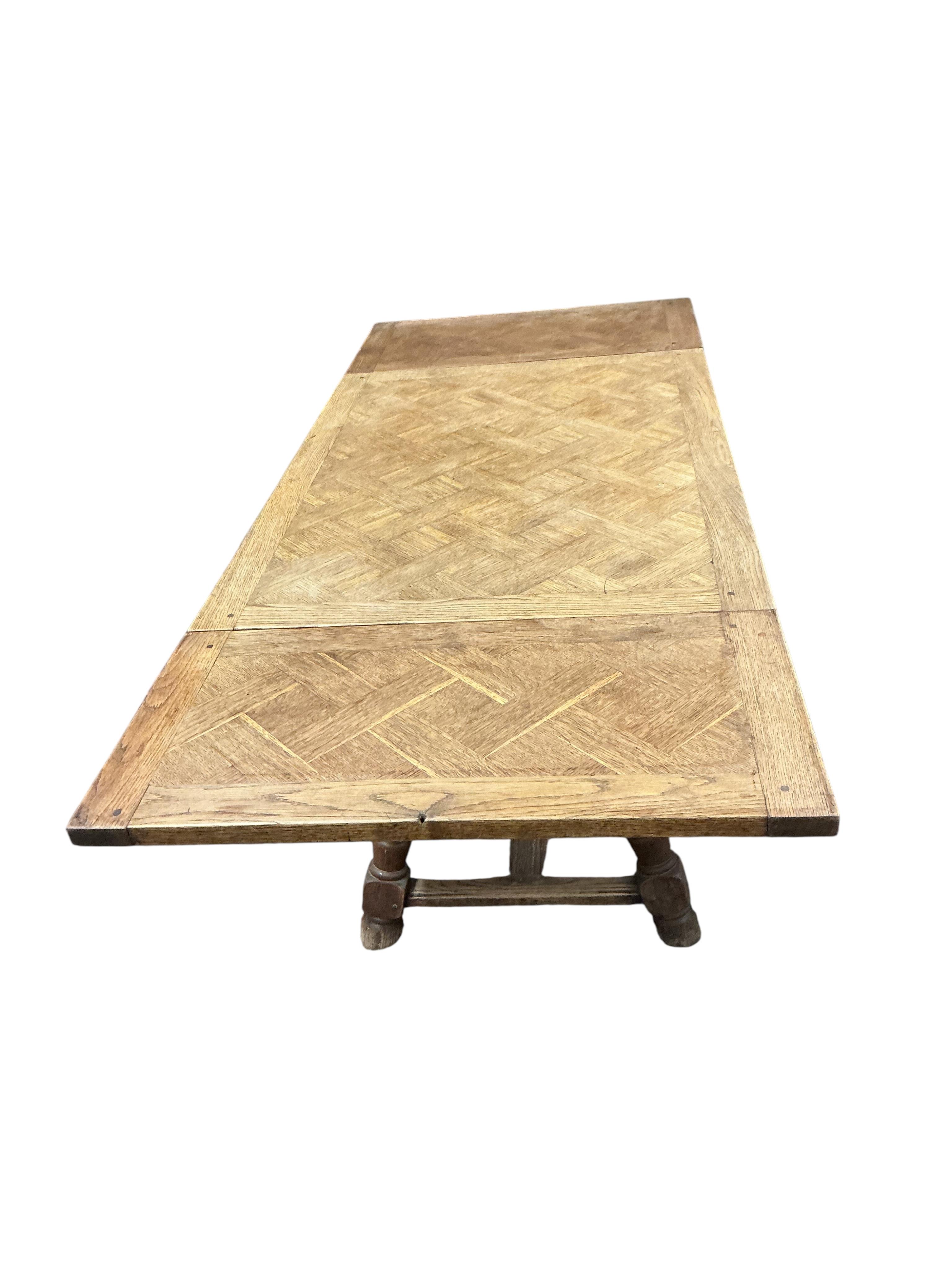 A small late 19th / early 20th century French parquetry oak draw leaf dining table, width 186cm extended, depth 79cm, height 74cm